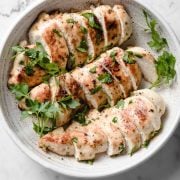 serving bowl with three sliced pan seared chicken breasts