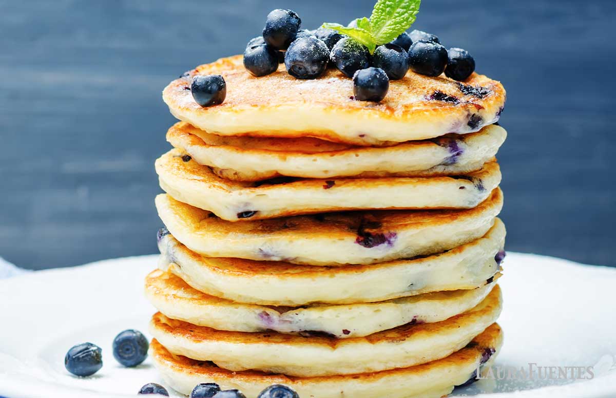 large stack of lemon blueberry pancakes topped with blueberries