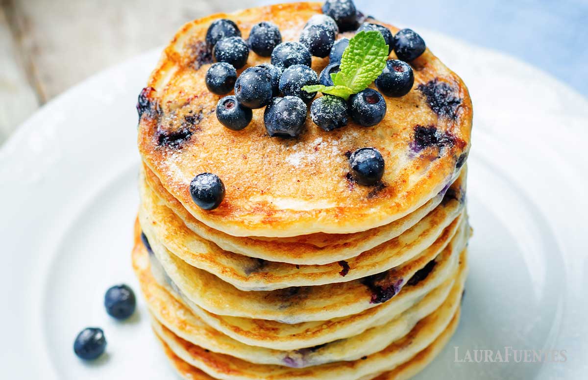 large stack of fluffy lemon blueberry pancakes topped with blueberries