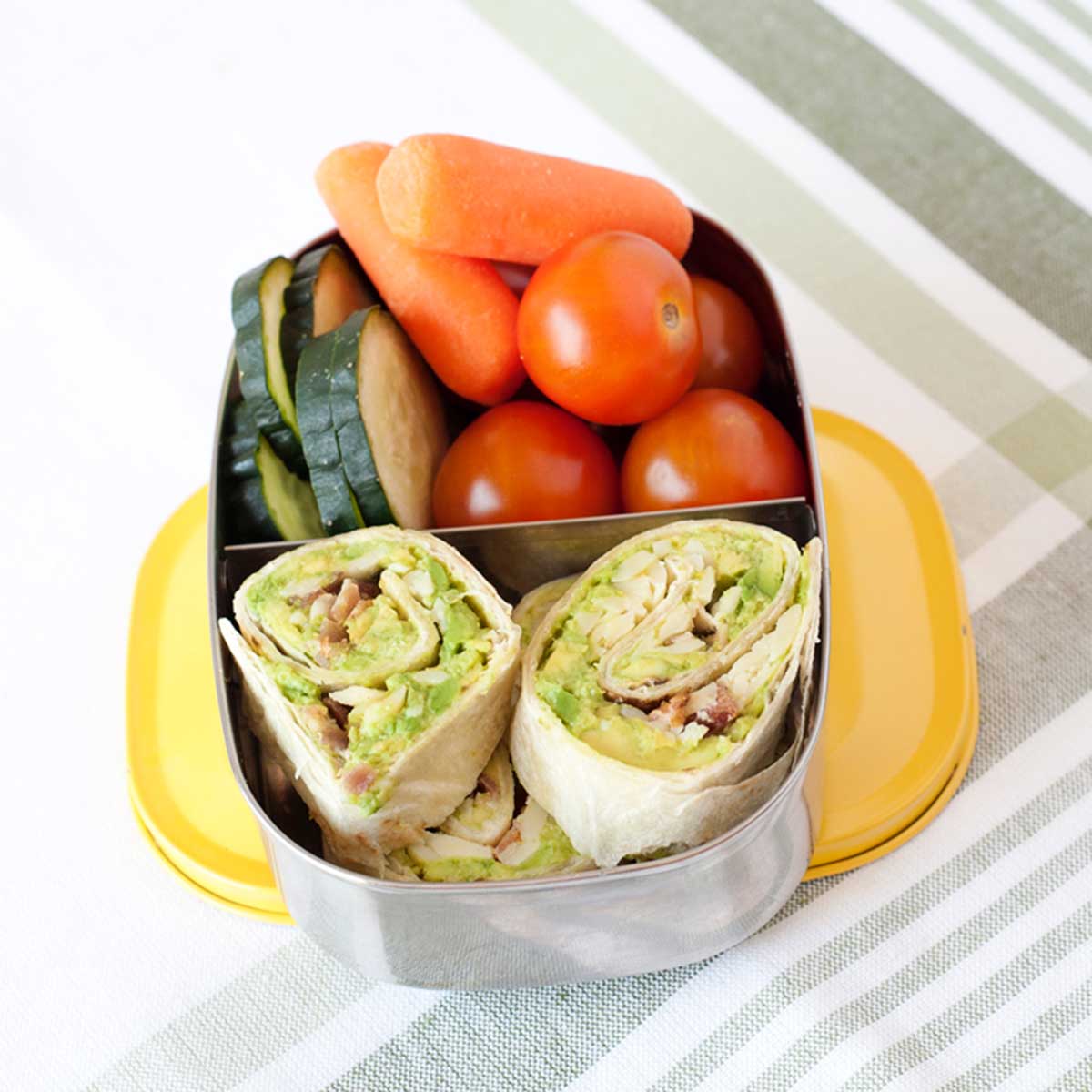 Avocado & Bacon Pinwheels and veggies in a lunchbox