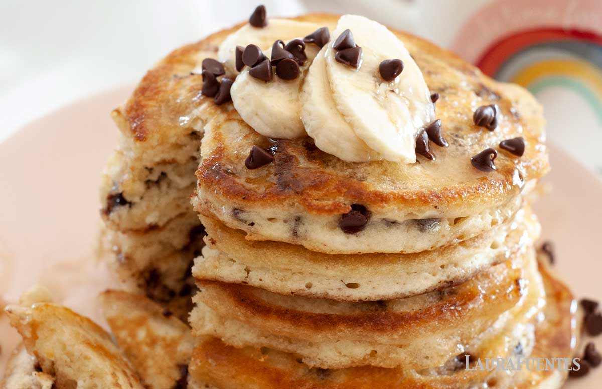 stack of chocolate chip pancakes with bananas on a plate cut