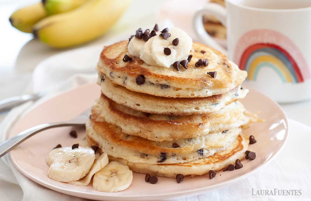 stack of chocolate chip pancakes with bananas on a plate cut