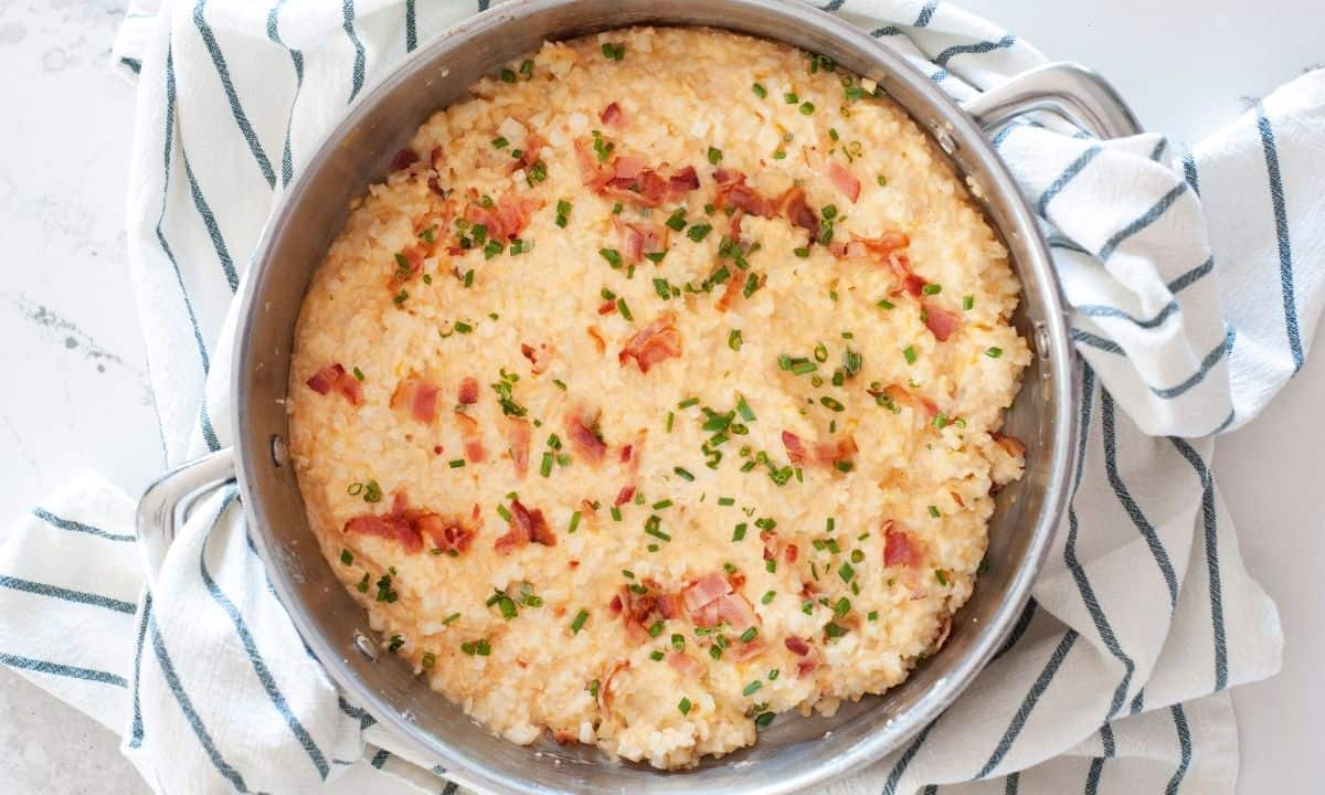 overhead view of cheesy cauliflower rice in a skillet