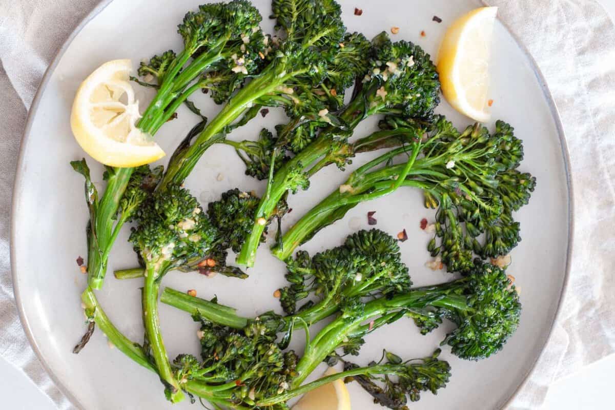 a plate with roasted broccolini and some lemon slices