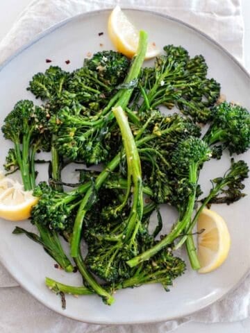 a plate with roasted broccolini and some lemon slices