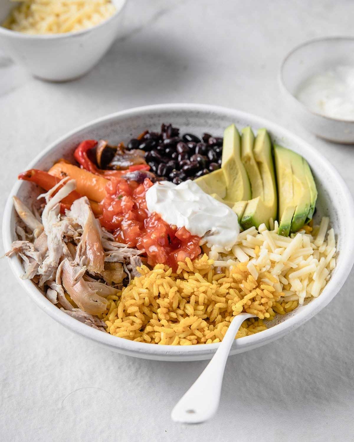 a large bowl of chicken fajitas with toppings