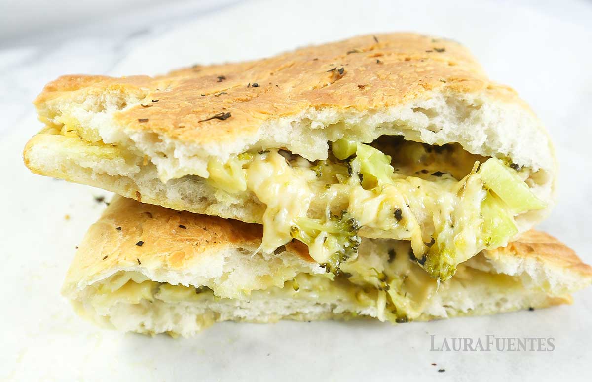 two halves of a broccoli cheese calzone