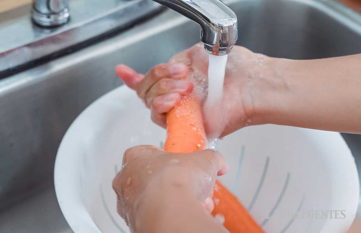 washing carrots in a sink