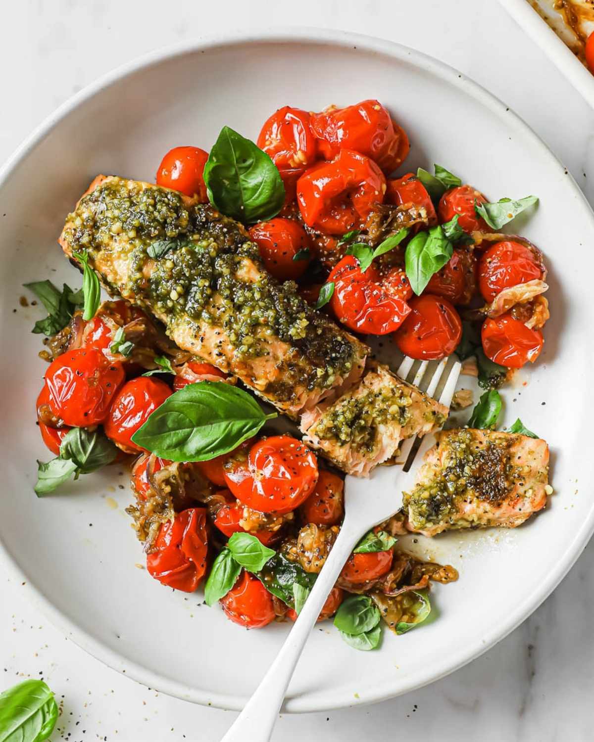 baked pesto salmon and cherry tomatoes on a plate