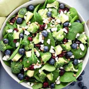 top view of blueberry spinach salad with broccoli and avocado in a large bowl