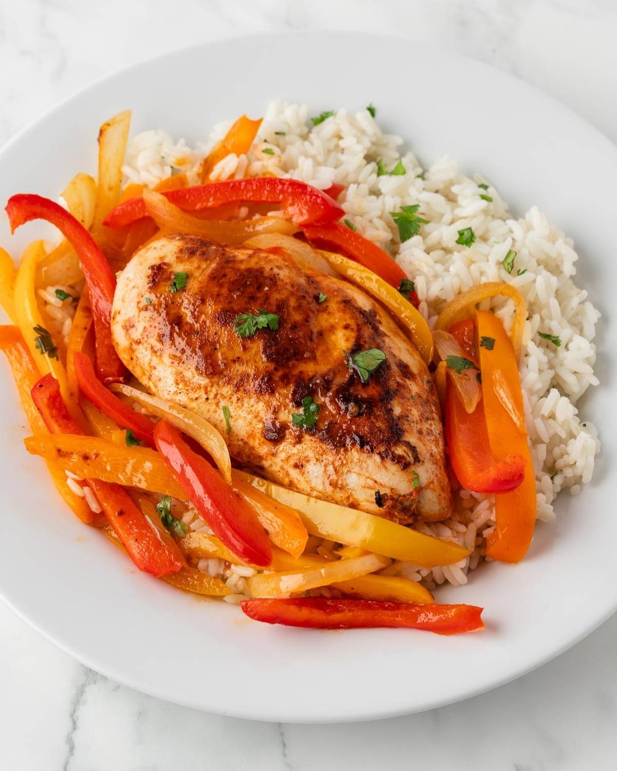 chicken with peppers and onions served over a bed of cilantro lime rice