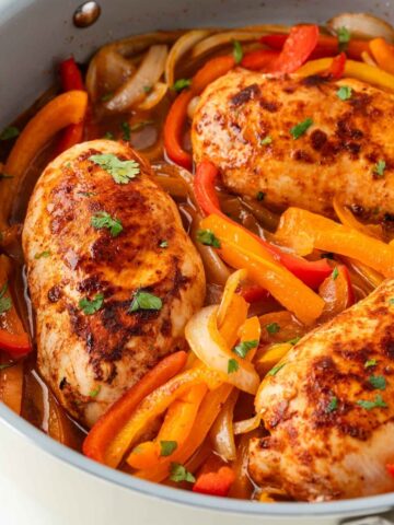 close up looking in the skillet of finished chicken with peppers and onions recipe