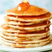 stack of rice flour pancakes on a plate with honey poured over it