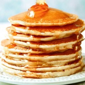 stack of rice flour pancakes on a plate with honey poured over it