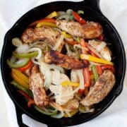 skillet of chicken tenders, sliced onions and sliced red, green and yellow peppers