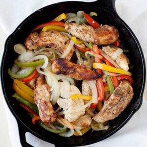 skillet of chicken tenders, sliced onions and sliced red, green and yellow peppers