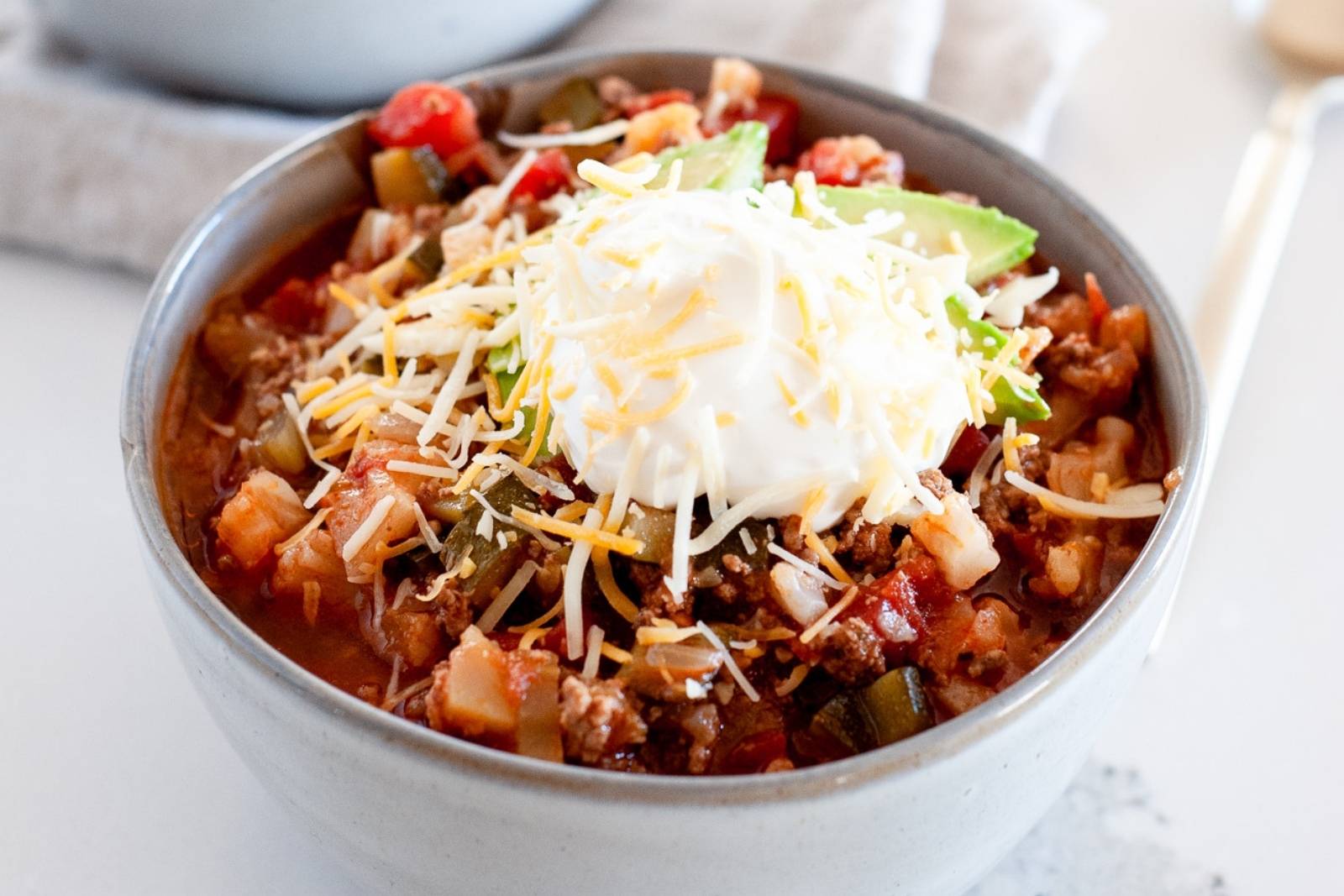 a bowl of keto chili with toppings