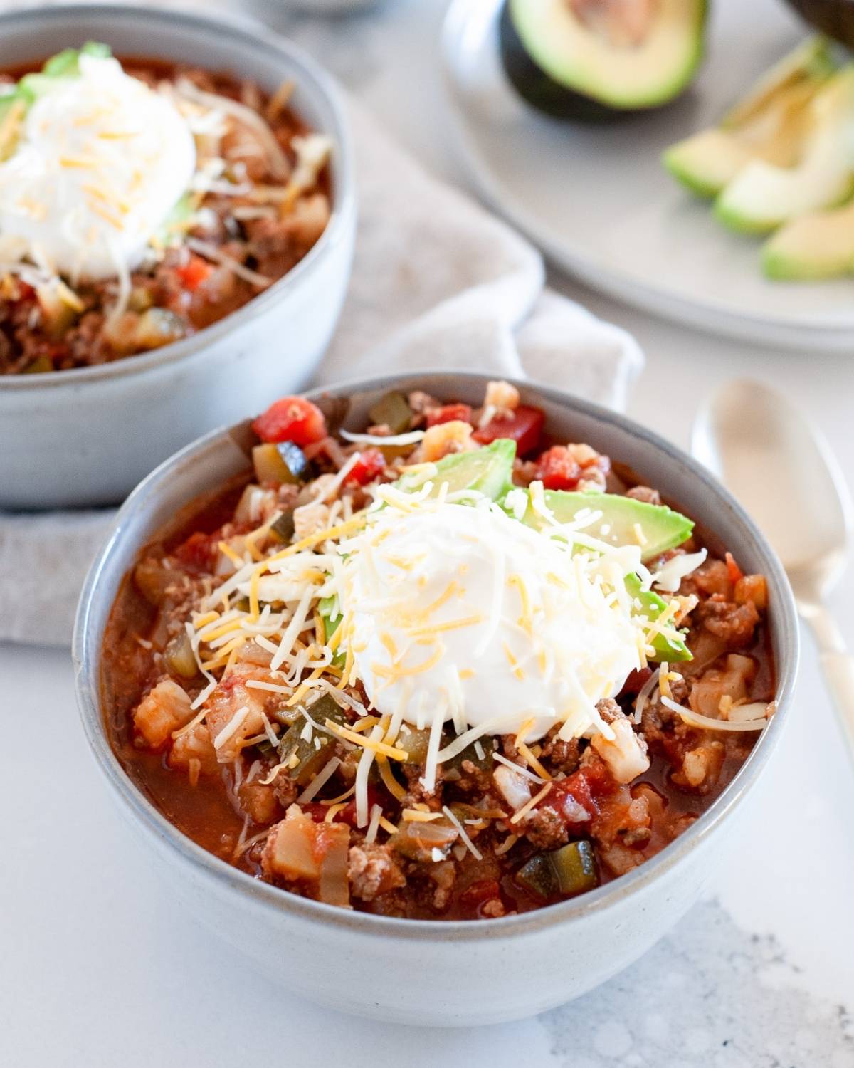 two bowls of keto chili with toppings