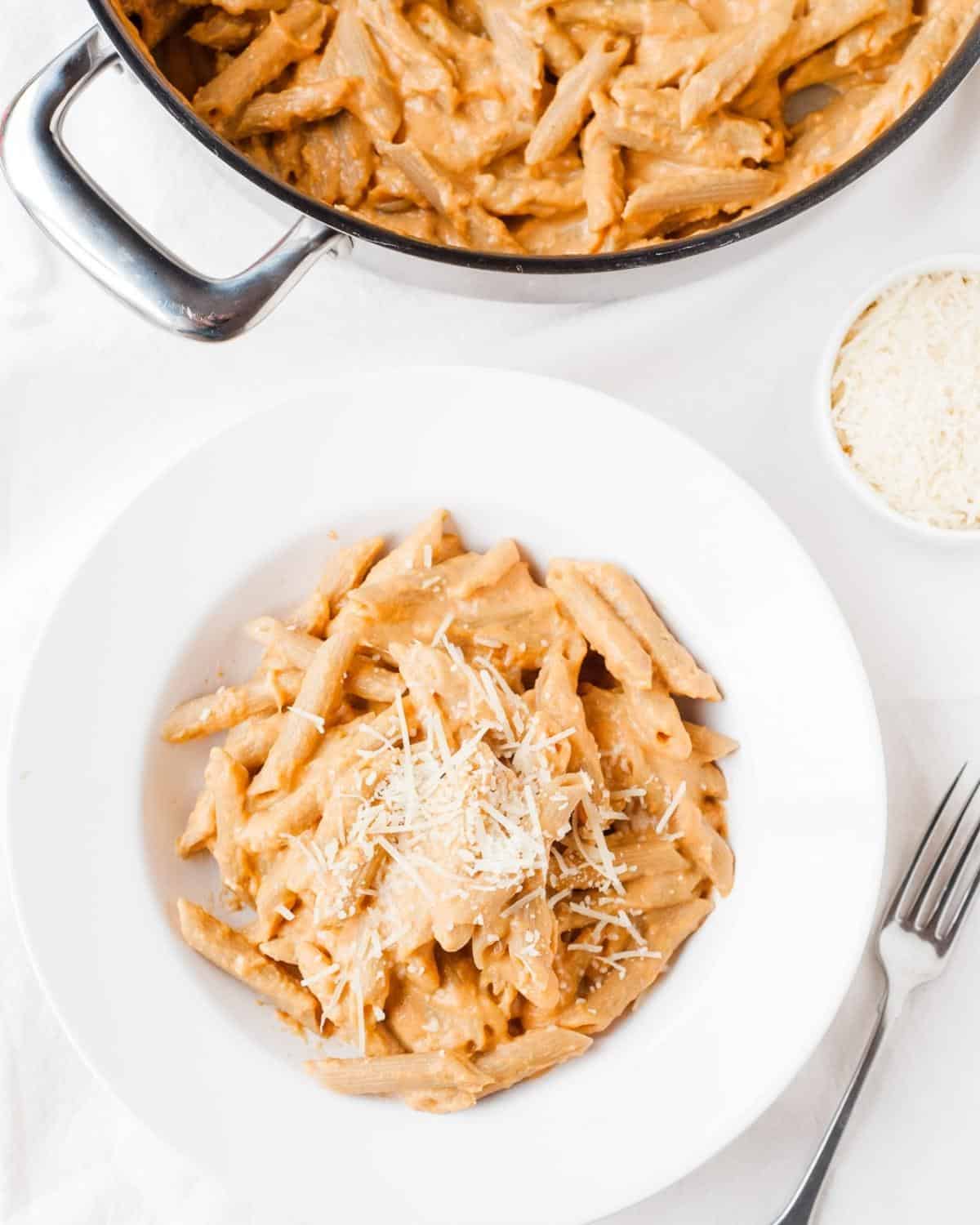 penne pasta with pumpkin sauce in a pot and a bowl
