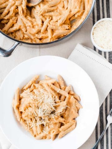 penne pasta with pumpkin sauce in a pot and a bowl