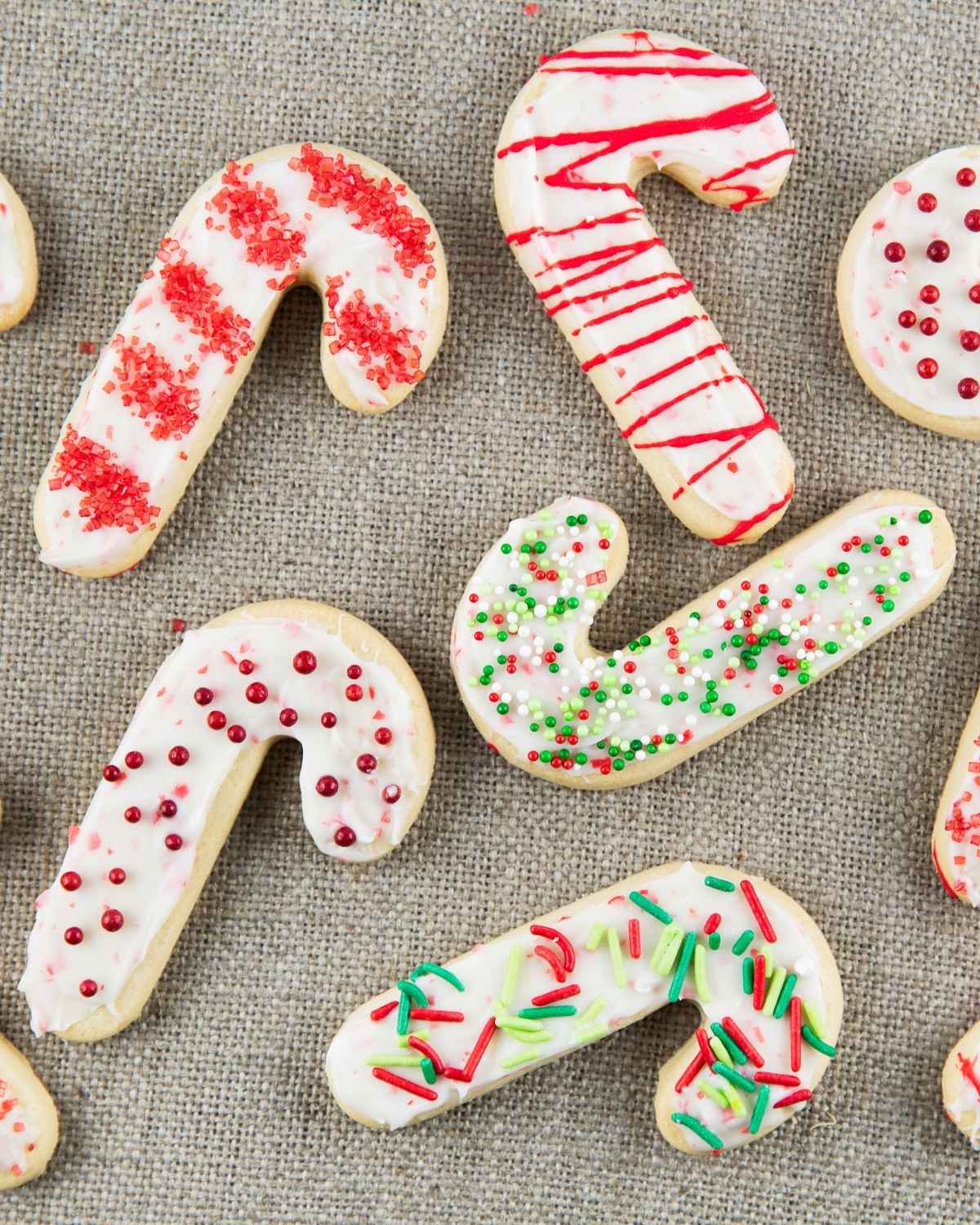 Candy cane–shaped sugar cookies decorated with white icing, and red and green sprinkles