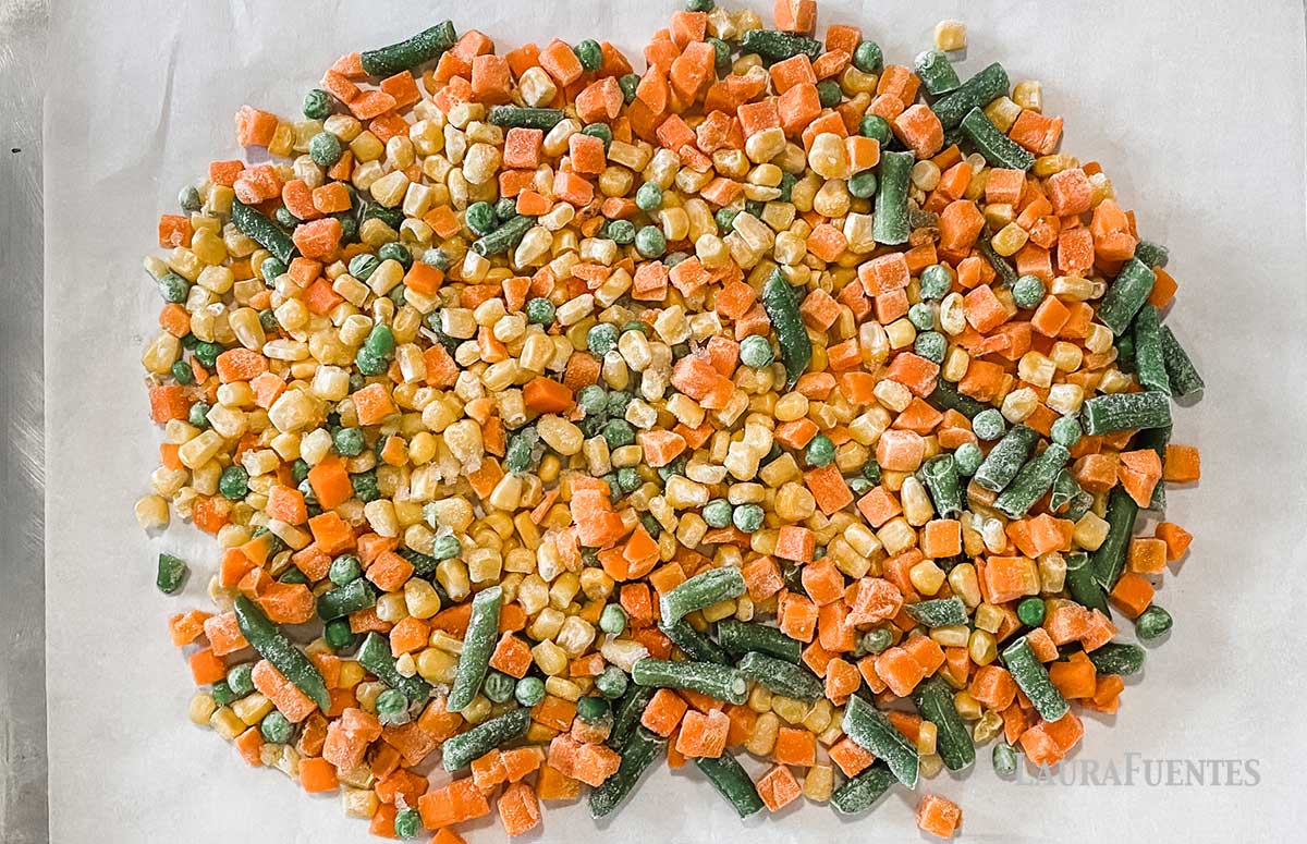 large sheet pan of frozen vegetables ready for roasting