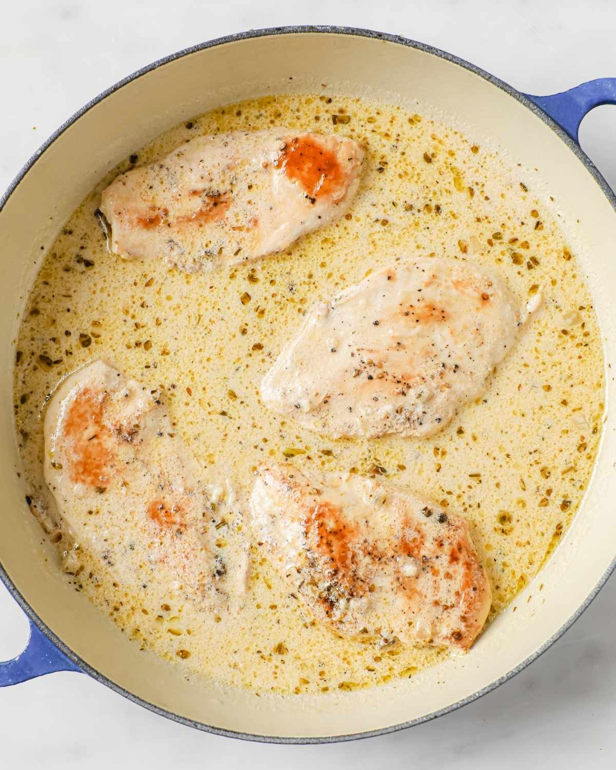 chicken breasts in a creamy sauce in a skillet