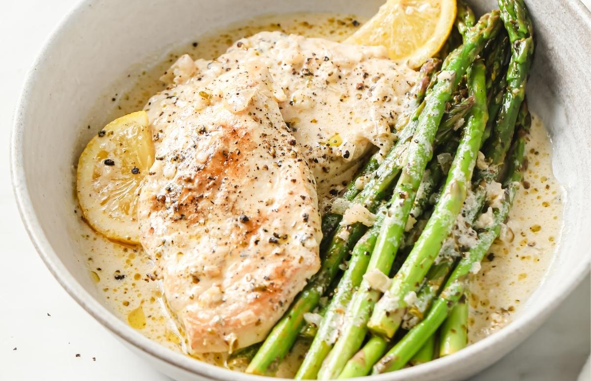 creamy lemon garlic chicken breasts with asparagus in a plate