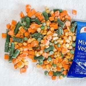 a frozen bag of vegetables pouring onto a baking sheet