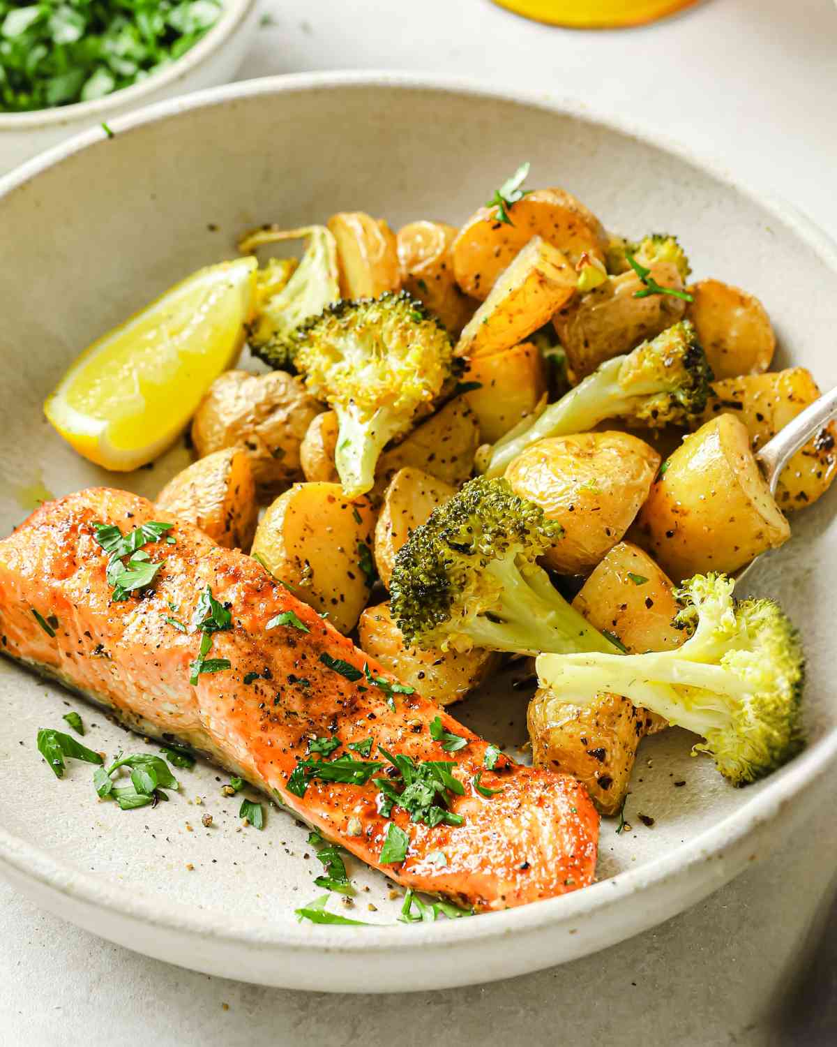 baked salmon and potatoes with broccoli served on a plate