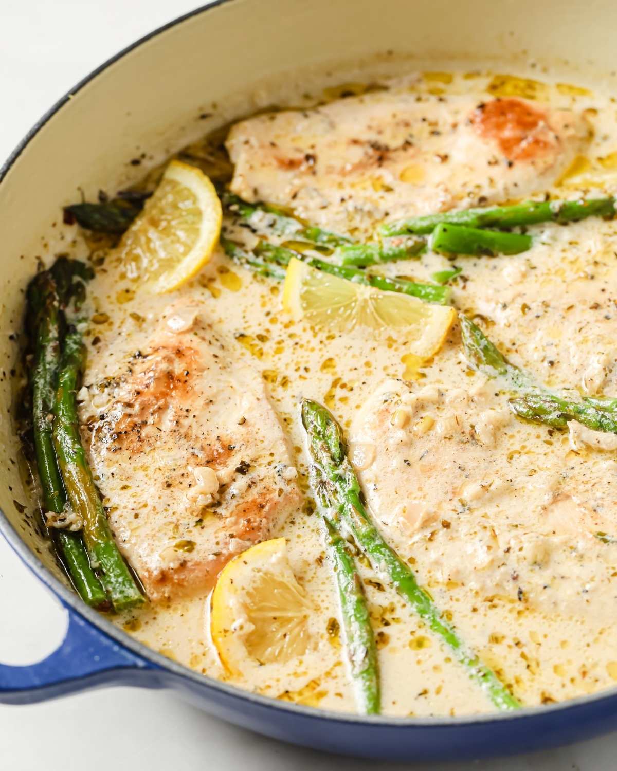chicken and asparagus in a large pan