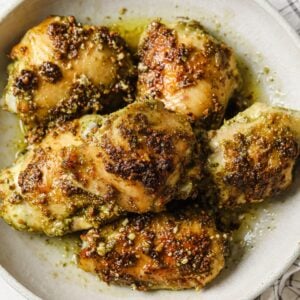 six pesto chicken thighs on a plate