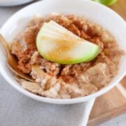 large bowl of oatmeal topped with sliced green apple