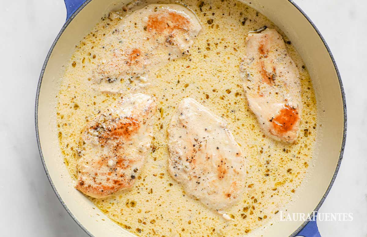 large bowl of lemon garlic sauce with chicken breasts