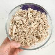 large glass bowl of shredded chicken thighs