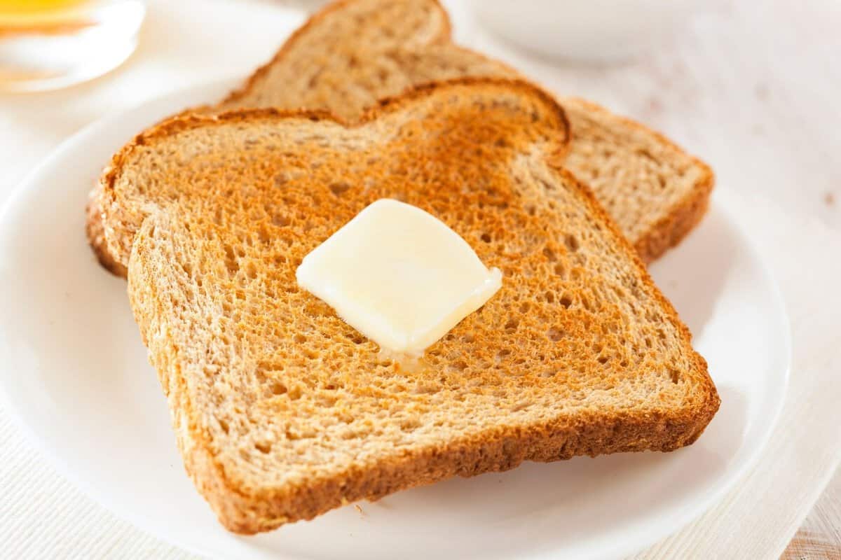 two bread slices toasted in a plate with some butter on top
