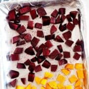 roasted cubed beets and butternut squash in a lined baking sheet