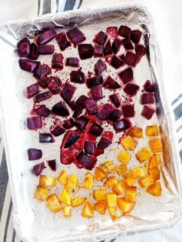 roasted cubed beets and butternut squash in a lined baking sheet