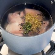 chicken thighs poaching in a large pot