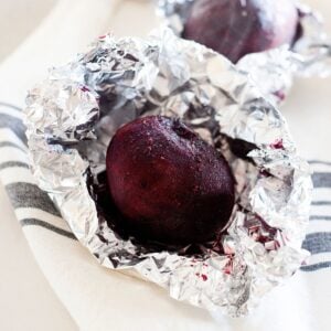 close up of a whole roasted beet inside foil