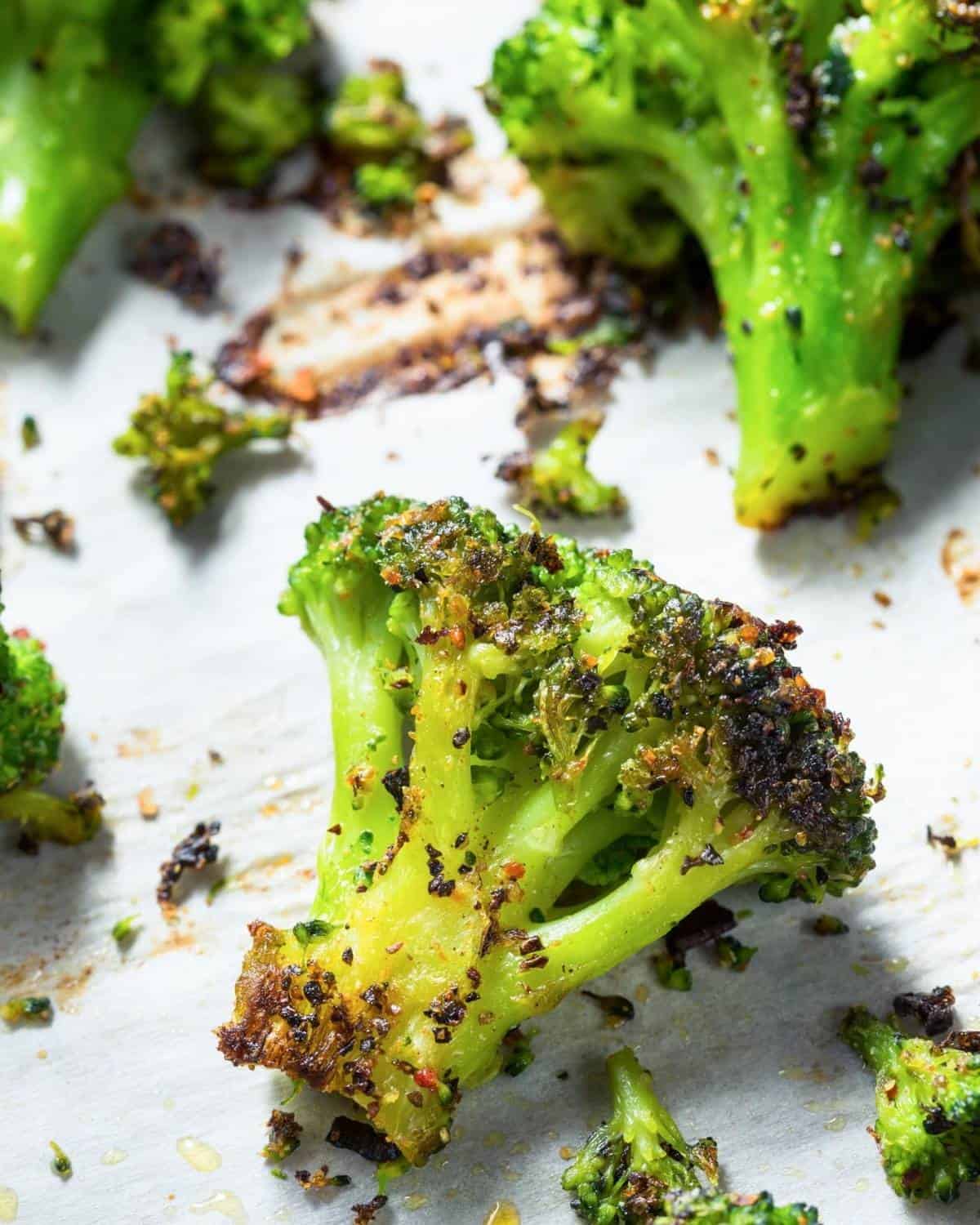 large baking sheet of roasted broccoli with seasoning