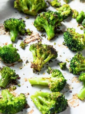 large baking sheet of roasted broccoli with seasoning