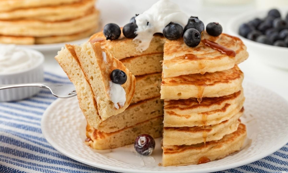 stack of Greek yogurt pancakes with a bite cut out of them on a fork