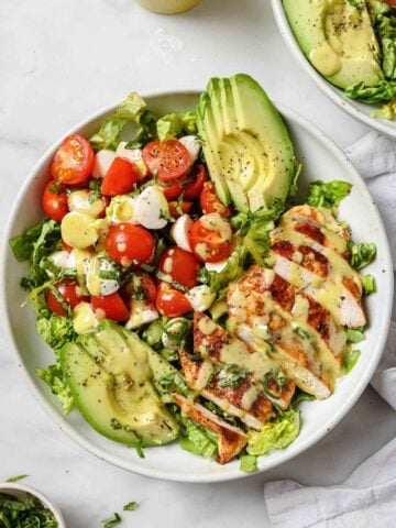 a big plate with blackened chicken salad with avocado, tomato, lettuce, and mozzarella balls