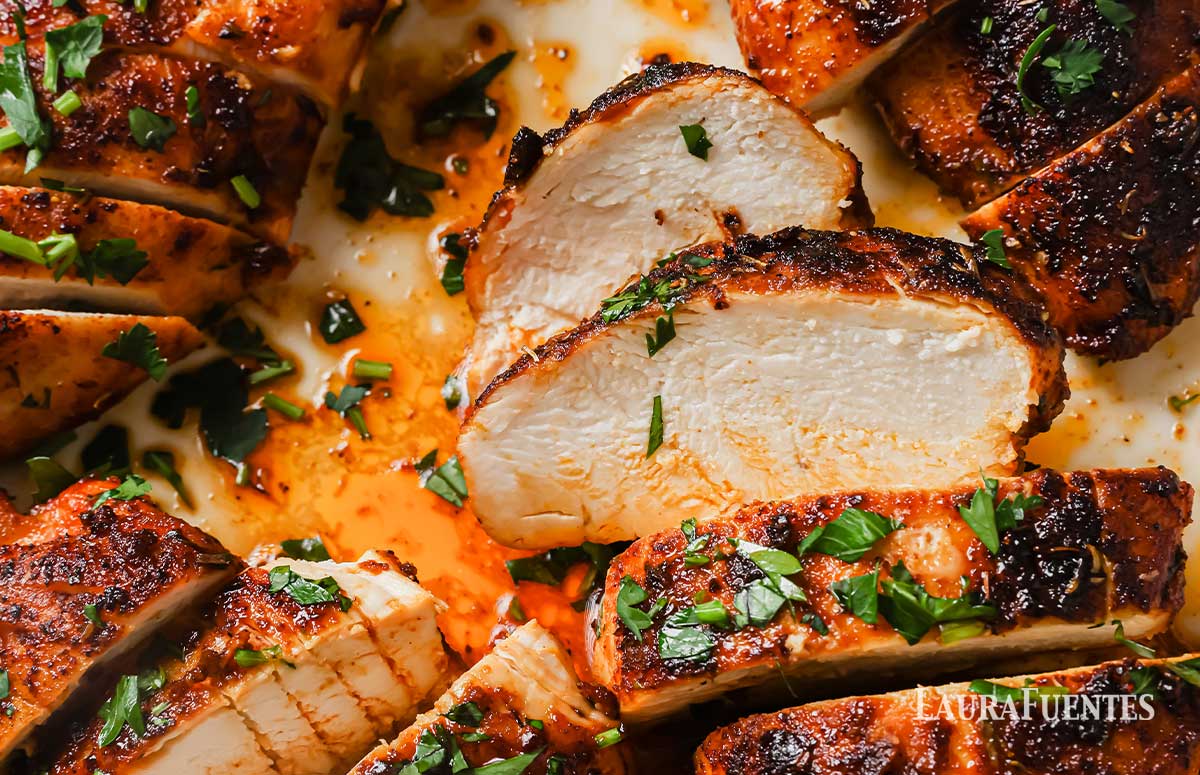 closeup of blackened chicken breasts that have been sliced on a plate