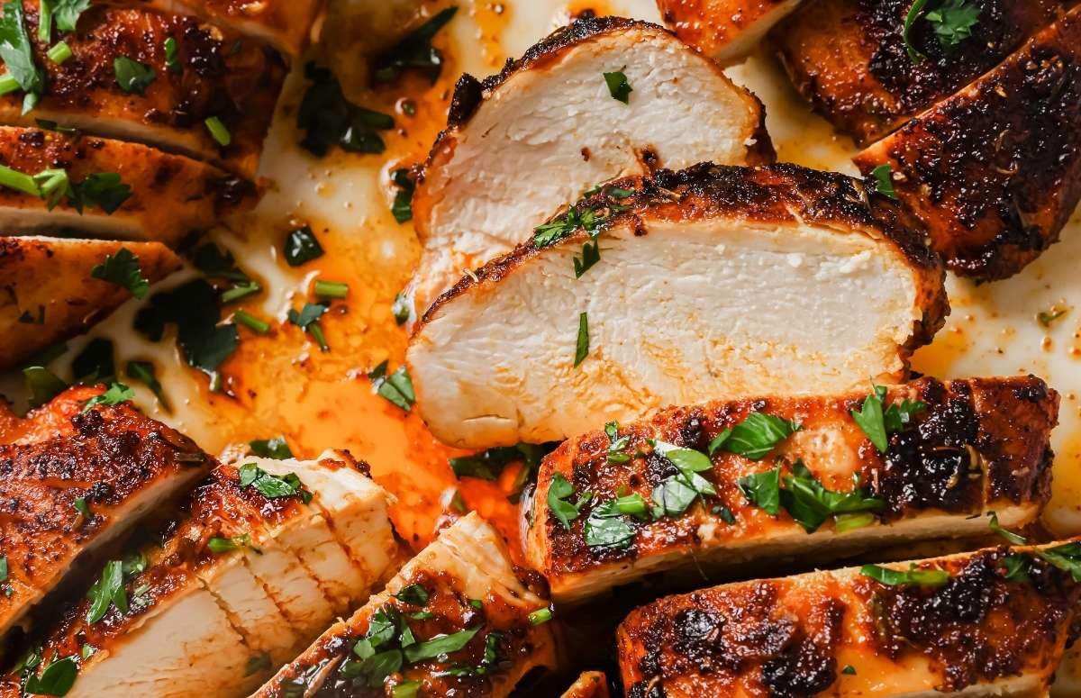 closeup of blackened chicken breasts that have been sliced on a plate