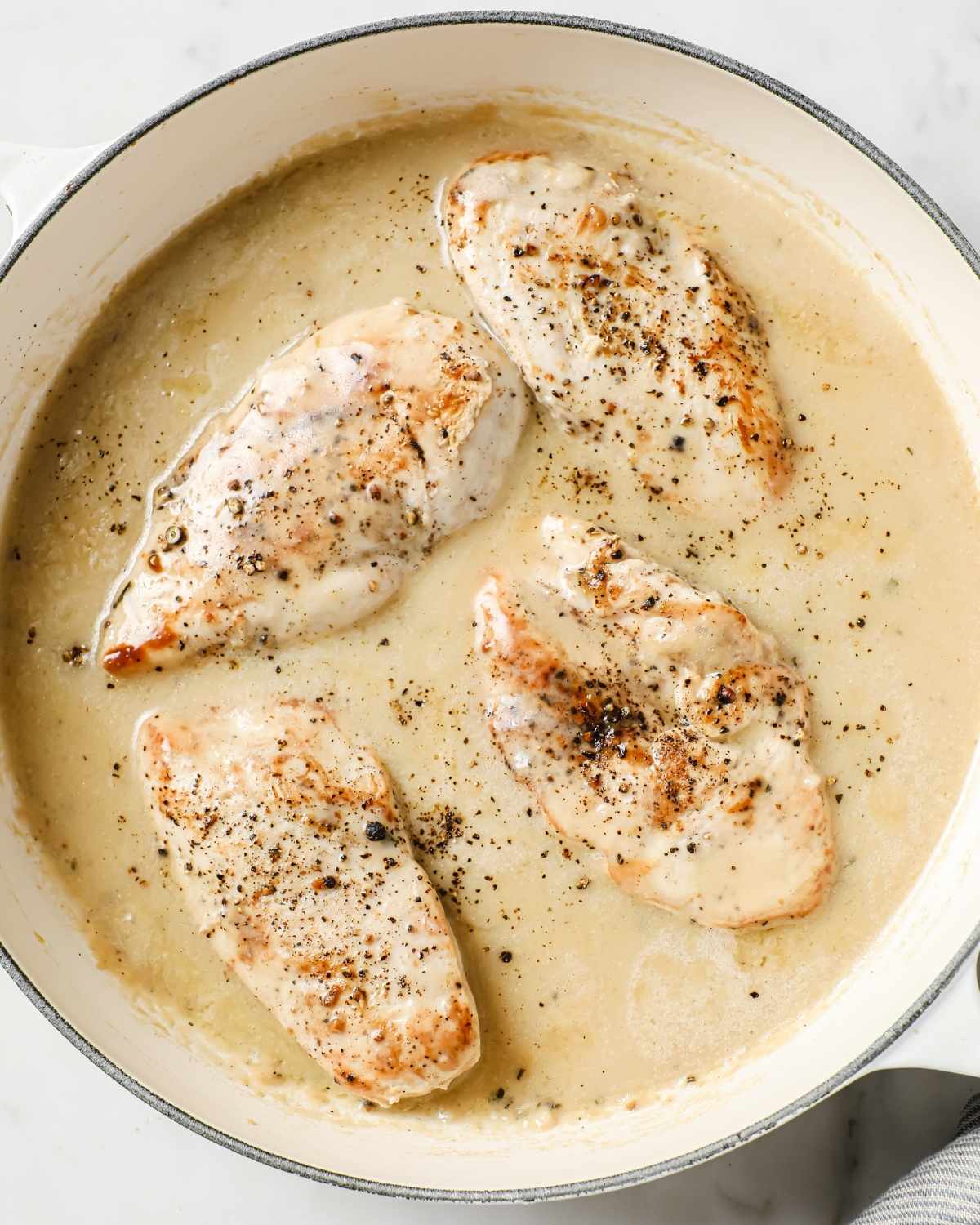 top view of four chicken breasts with cream