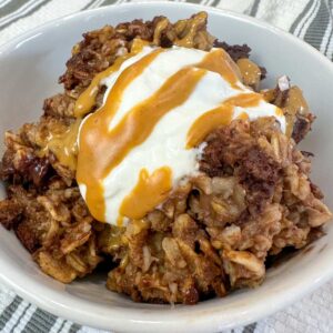 a bowl of chocolate baked oatmeal topped with Greek yogurt and peanut butter