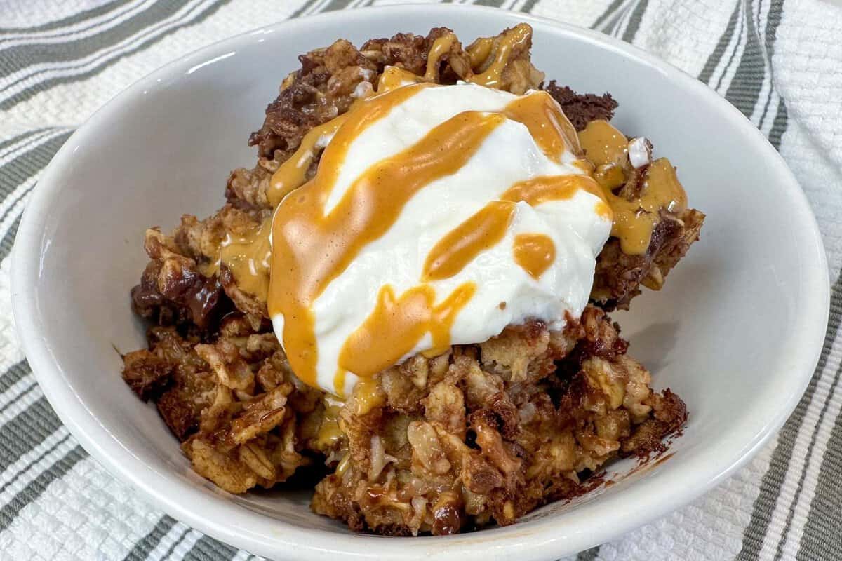 a bowl of chocolate baked oatmeal topped with Greek yogurt and peanut butter