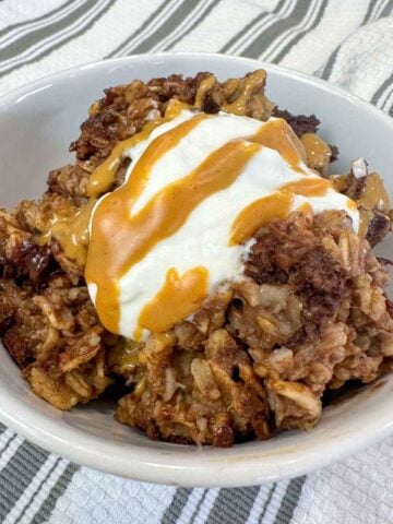 a bowl of chocolate baked oatmeal topped with Greek yogurt and peanut butter